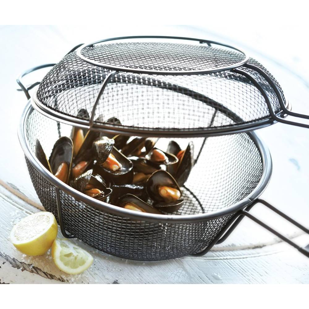 Metal mesh outdoor grill basket and skillet with handle, shown filled with cooked mussels and lemon wedges, designed for versatile grilling and smoky flavor infusion in cookware and grilling collections.