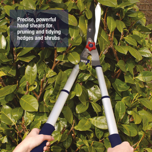 Telescopic aluminum hand shears with twist and lock handles extending for extra reach, shown pruning dense green shrubbery, part of Farm, Garden & Tool and Lawncare collections.