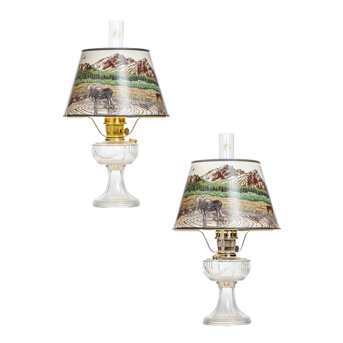 Pair of clear glass oil lamps featuring brass burners and Rocky Mountain scenic parchment shades, ideal for Lamps & Lighting, Oil Lamps, Table Lamps, Best Sellers, and Promo Eligible collections.