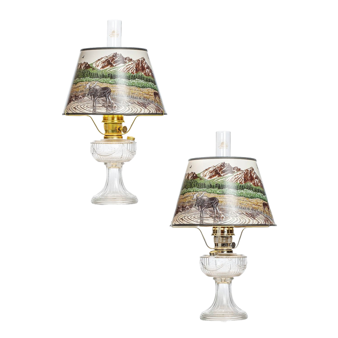 Pair of clear glass oil lamps featuring brass burners and Rocky Mountain scenic parchment shades, ideal for Lamps & Lighting, Oil Lamps, Table Lamps, Best Sellers, and Promo Eligible collections.