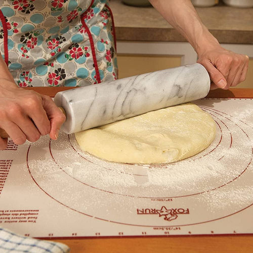 Hands using a smooth marble rolling pin to roll out dough on a floured pastry mat in a warm kitchen environment, part of Kitchen & Food, Cookware, and Baking Supplies collections.
