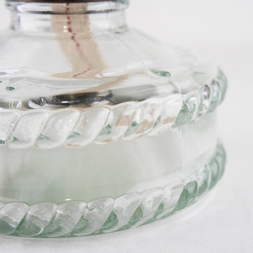 Close-up of a clear glass fuel base with a twisted pattern, showing the fabric wick inside, handcrafted oil lamp suitable for Lamps & Lighting, Oil Lamps, Wall Lamps, and Best Sellers collections.