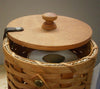 Handcrafted Amish-made paper towel holder featuring woven basket sides, smooth wooden lid with knob, designed for neat storage and easy access in Home & Decor and Household Helpers collections.