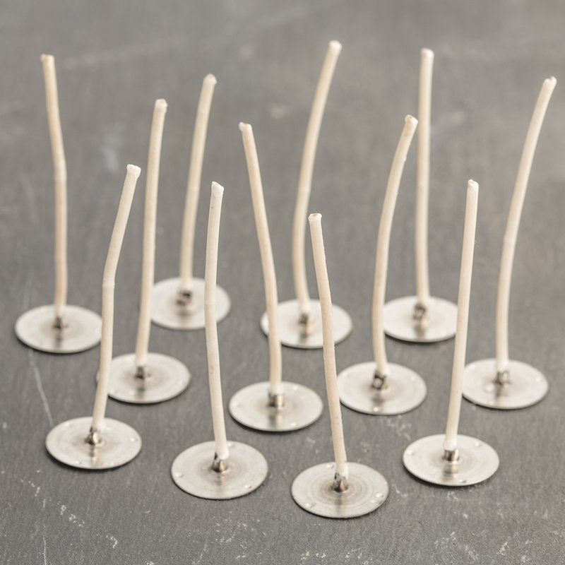 Set of pre-waxed paper wick tabs with metal bases, handcrafted in the USA for use in votive and small container candles, featured in Candlemaking Supplies and Lamps & Lighting collections.