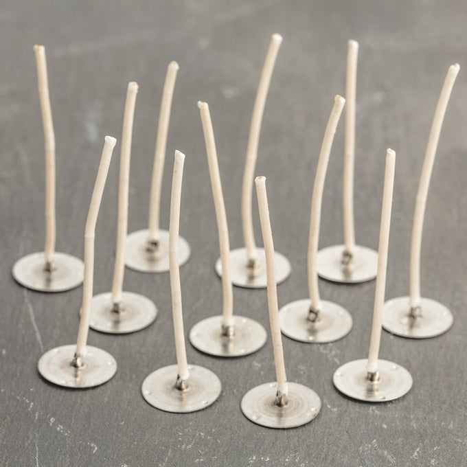 Set of pre-waxed paper wick tabs with metal bases, handcrafted in the USA for use in votive and small container candles, featured in Candlemaking Supplies and Lamps & Lighting collections.
