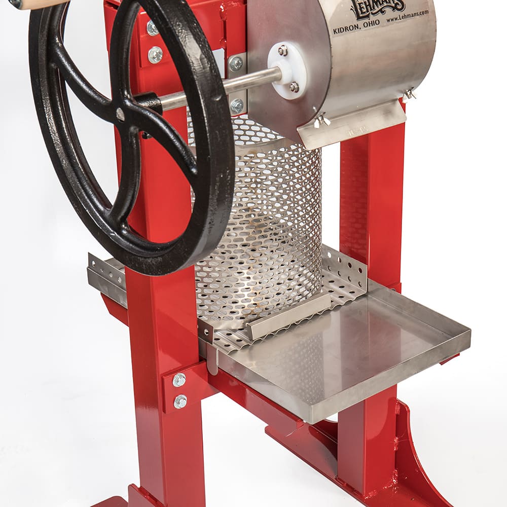 Handcrafted stainless steel fruit press with a red frame and black cast iron crank, designed for orchard and garden use, featured in Farm, Garden & Tool and USA Made collections.