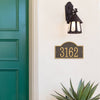Custom bronze and gold arched rectangle address plaque with raised numbers mounted on a light stucco wall beneath a black vintage-style outdoor lantern, enhancing curb appeal in Home & Decor, USA Made, and Mailboxes and Address Signs collections.