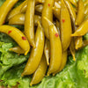 Close-up of handcrafted pickled snap peas with visible chili flakes, arranged on fresh green lettuce, highlighting USA made quality in Kitchen & Food and Pantry collections.