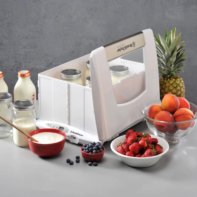 Brod & Taylor bread proofer and slow cooker with transparent sides holding glass jars, surrounded by fresh berries, peaches, pineapple, and milk bottles, ideal for Kitchen & Food and Baking Supplies collections.