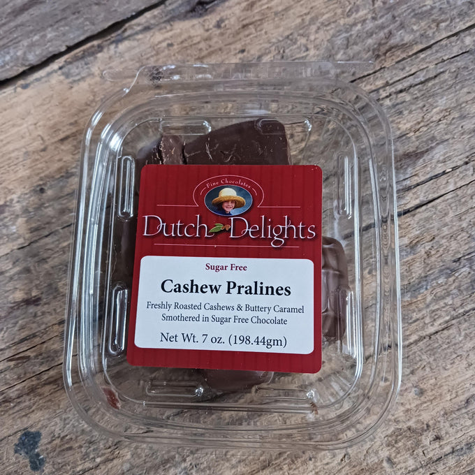 Clear plastic container holding handcrafted sugar-free chocolate cashew pralines with freshly roasted nuts and buttery caramel, ideal for Kitchen & Food, Snacks and Sweets, Candy, USA Made, Best Sellers collections.