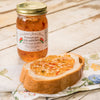 Handcrafted jalapeno jam jar with visible chili pieces beside a slice of bread spread with the jam, featured in Kitchen & Food, Pantry, USA Made, and Best Sellers collections.