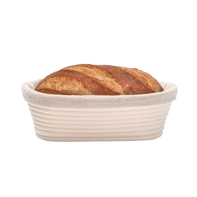 Handcrafted oval rattan bread proofing basket with a removable cloth liner holding a golden sourdough loaf, designed for even rising in Kitchen & Food, Baking Supplies, and Bread Making collections.