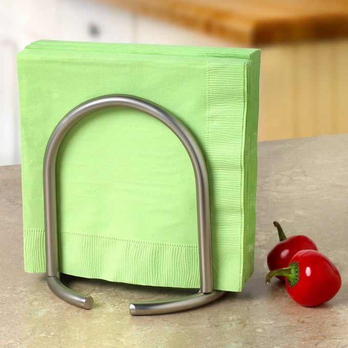 Upright stainless steel napkin holder with satin nickel finish holding green napkins on a kitchen countertop next to two small red peppers, ideal for Home & Decor and Kitchen & Food collections.