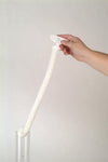 Hand holding a soft, flexible white foam brush with plastic handle, cleaning a glass lamp chimney, highlighting its durable design, made in USA, featured in Lamps & Lighting and Parts and Accessories collections.