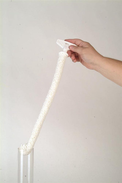 Hand holding a soft, flexible white foam brush with plastic handle, cleaning a glass lamp chimney, highlighting its durable design, made in USA, featured in Lamps & Lighting and Parts and Accessories collections.