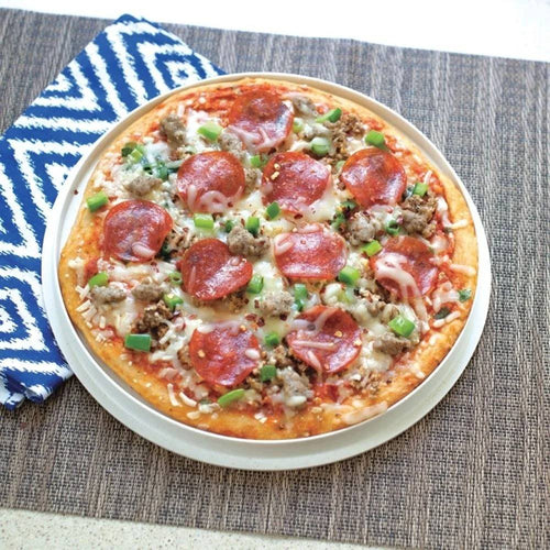Round microwave-safe white plate with a cooked pepperoni and sausage pizza topped with green bell peppers, set on a textured surface next to a blue and white patterned cloth, featured in Kitchen Gadgets and Best Sellers collections.