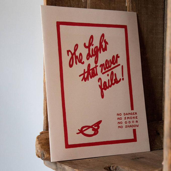 Paperback booklet with bold red hand-lettered text reading "The Light that never fails!" and safety notes, styled simply for heritage and lifestyle book collections.