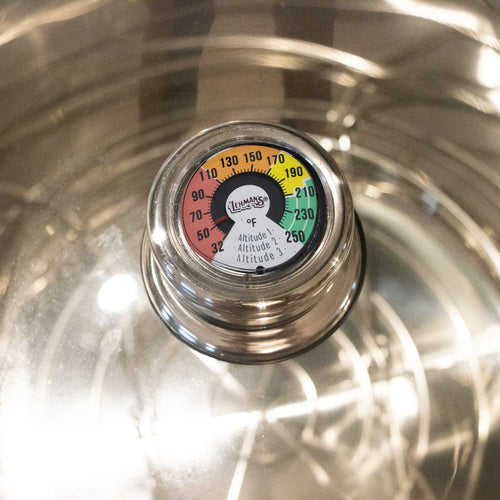 Close-up of Lehman's built-in temperature gauge on a stainless steel canner lid, showing a colorful dial for precise heat monitoring, featured in Kitchen & Food and Food Preservation collections.