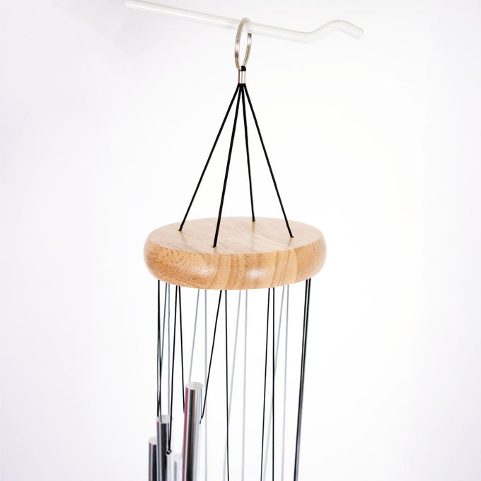 Handcrafted wind chime featuring a smooth wooden top and silver metal tubes suspended by black cords, perfect for garden accessories and outdoor relaxation.