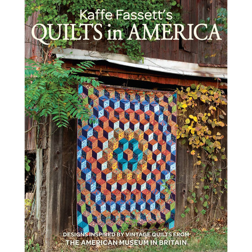 Colorful geometric quilt with intricate patchwork hanging on a rustic wooden barn wall surrounded by green foliage, featured in a handcrafted quilting book from Toys, Books & Games and Home and Garden How-To Books collections.