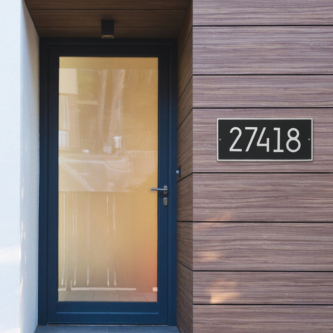 Handcrafted modern black and silver address plaque mounted on wood-paneled exterior near a glass door, enhancing curb appeal in Home & Decor and USA Made collections.
