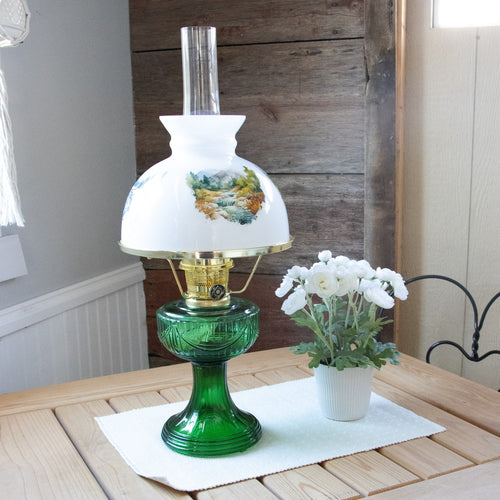 Handcrafted 10-inch white glass lamp shade featuring seasonal mountain stream landscape illustrations, paired with green glass oil lamp base, perfect for Lamps & Lighting, Parts and Accessories, and Lamp Shades collections.