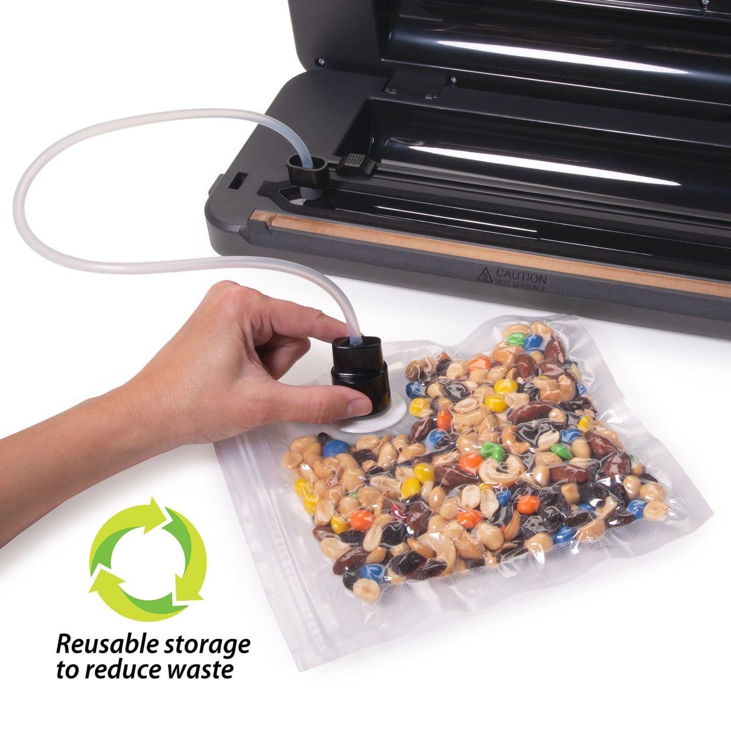 Hand using a vacuum sealer machine port to remove air from a clear reusable vacuum zipper bag filled with mixed nuts and candy, promoting food preservation and waste reduction in Kitchen & Food collections.