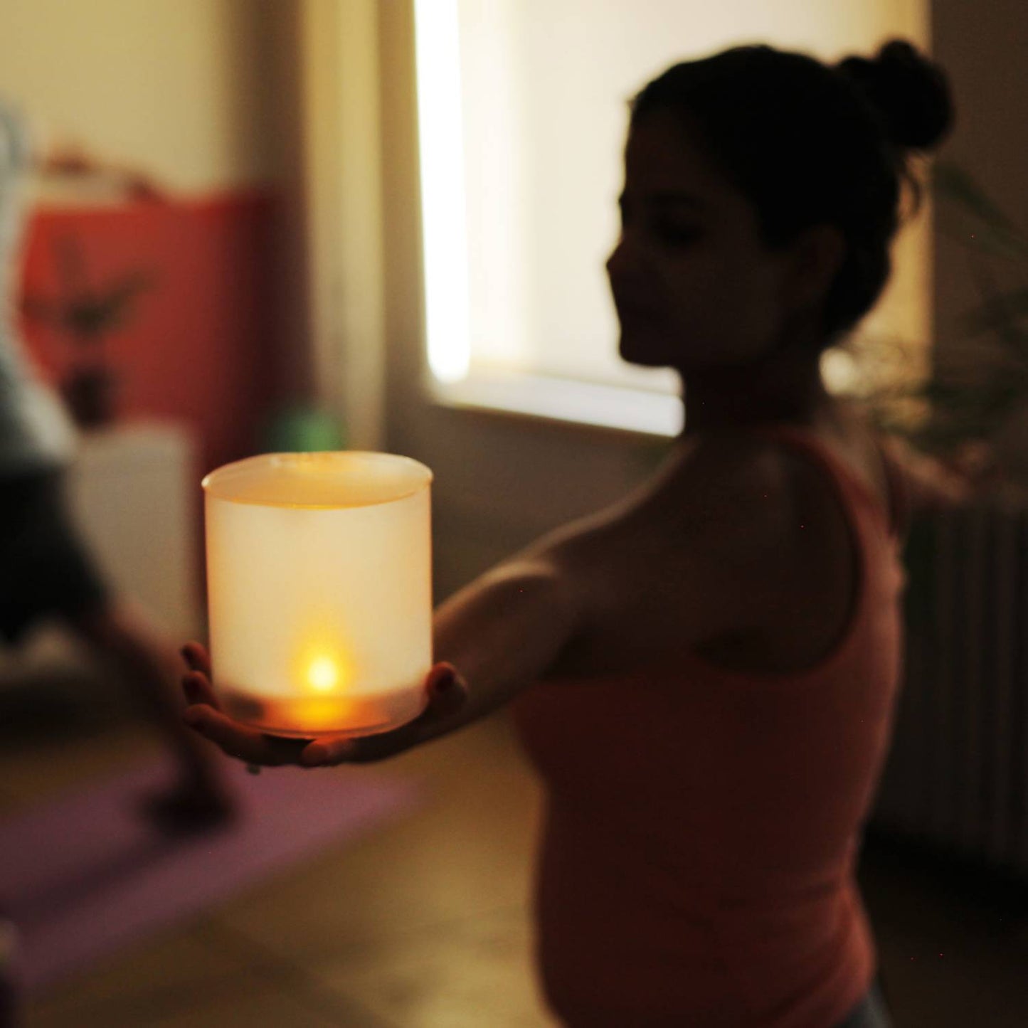 Woman holding a glowing solar LED candle that emits a warm flickering light, perfect for cozy indoor ambiance and featured in Lamps & Lighting and Candles collections.