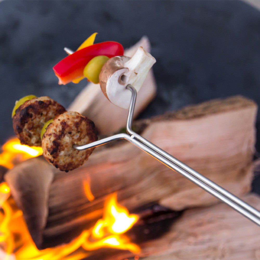 Handcrafted stainless steel skewer with adjustable length holding grilled vegetables and meatballs over an open campfire, perfect for Farm, Garden & Tool, Camping, Best Sellers, and Promo Eligible collections.