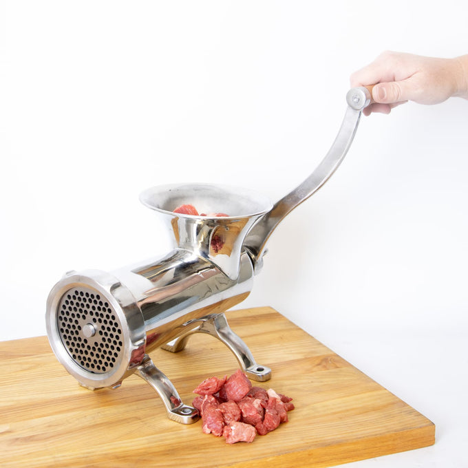 Handcrafted stainless steel meat grinder with mounted design, featuring a smooth crank handle and fresh meat being processed on a wooden surface, perfect for Kitchen & Food, Specialty Equipment, Butchering Supplies, Best Sellers, Promo Eligible collections.