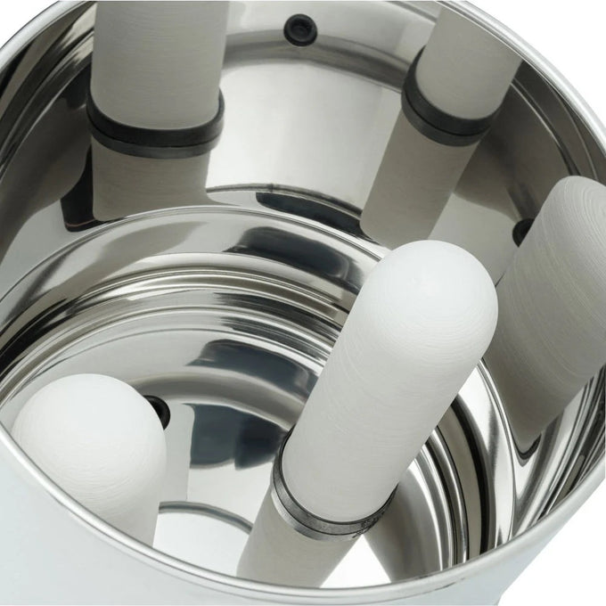 Close-up view inside a polished stainless steel gravity water filter showing four cylindrical ceramic filter elements securely mounted for effective water purification.