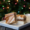 Two bite-sized, creamy fudge pieces with swirls of caramel and chocolate on a white plate, showcasing handcrafted Amish-made quality, ideal for Kitchen & Food and Snacks and Sweets collections.