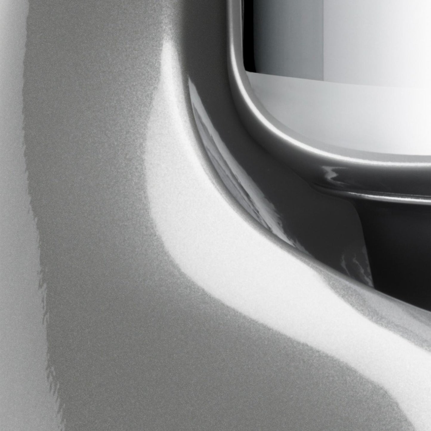 Close-up of a glossy silver-gray handcrafted stand mixer base with smooth curves and part of a polished stainless steel bowl, ideal for Kitchen & Food, Baking Supplies, and Cooking and Baking Helpers collections.