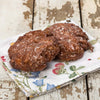 Two handcrafted glazed fruit fritters with a shiny sweet coating, resting on a floral cloth over rustic wooden surface, ideal for Kitchen & Food, Snacks and Sweets, Holiday Hosting, USA Made, Best Sellers, and Promo Eligible collections.