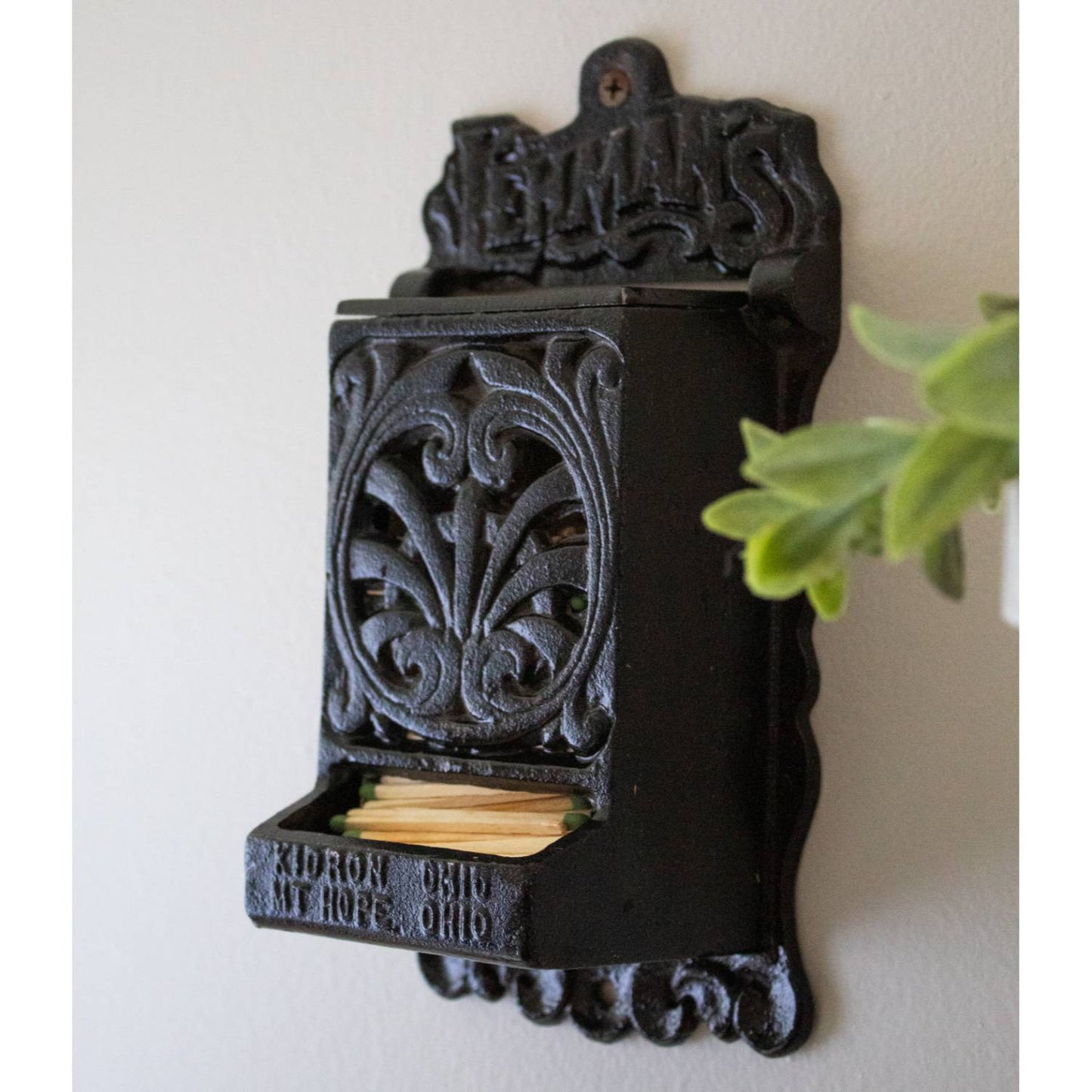 Handcrafted black cast iron wall-mounted matchbox holder with intricate vintage scrollwork and embossed "Lehman's" branding, made in USA, ideal for Home & Decor and Household Helpers collections.