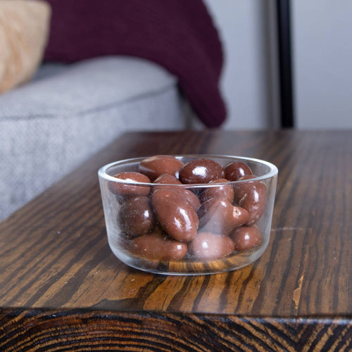 Clear glass bowl filled with glossy milk chocolate coated nuts including cashews, almonds, pecans, and Brazil nuts, handcrafted and made in USA, ideal for Kitchen & Food, Snacks and Sweets, Candy, USA Made, Best Sellers collections.