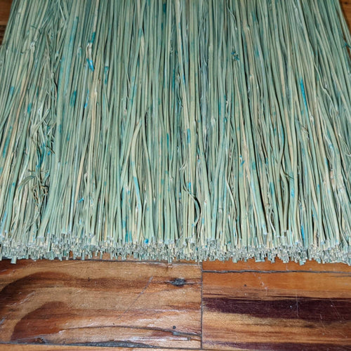 Close-up of tightly bundled natural corn straw bristles with subtle blue accents on a handcrafted Amish-made broom, resting on a wooden surface, featured in Home & Decor and Household Cleaning collections.