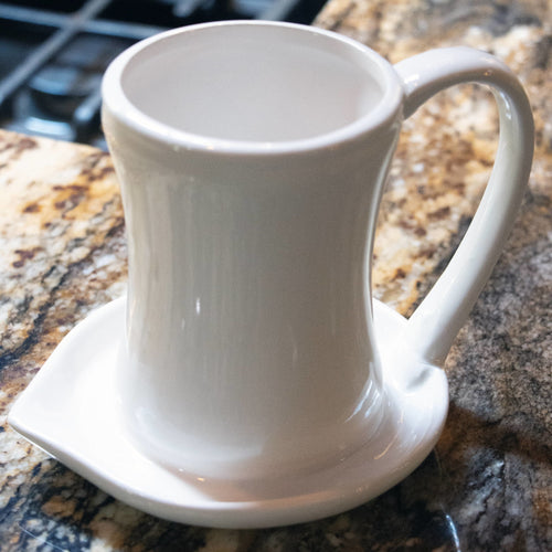 Cream-colored ceramic bacon cooker with a handle and wide base designed to catch grease, handcrafted for easy microwave use and featured in Kitchen & Food, Kitchen Gadgets, and Cooking and Baking Helpers collections.
