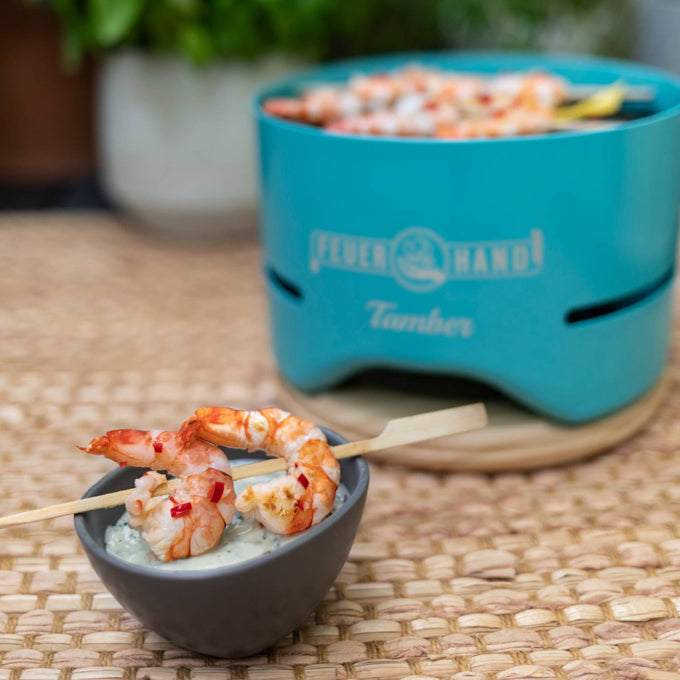 Handcrafted turquoise tabletop charcoal grill with shrimp skewers cooking over low heat, served with dipping sauce in a gray bowl, featured in Farm, Garden & Tool and Grilling collections.