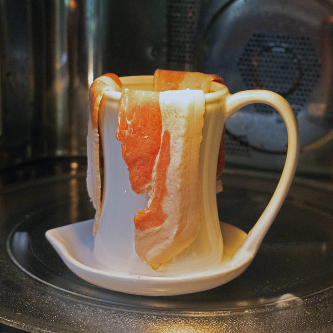 Cream-colored ceramic bacon cooker holding raw bacon strips draped over the cup with a grease-catching base, ideal for Kitchen & Food and Cooking and Baking Helpers collections.