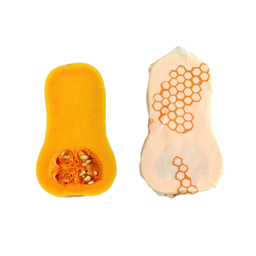 Handmade large muslin food wrap with beeswax coating featuring honeycomb pattern, shown wrapped around a halved butternut squash, ideal for Kitchen & Food and Storage collections.