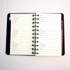 Open spiral-bound logbook featuring alphabetical tabs and lined pages for recording website addresses, usernames, passwords, and notes, designed as a handy household helper and best seller.
