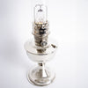Polished chrome oil lamp with a bright wick and glass chimney, handcrafted and designed for lamps and lighting, oil lamp, and table lamp collections.
