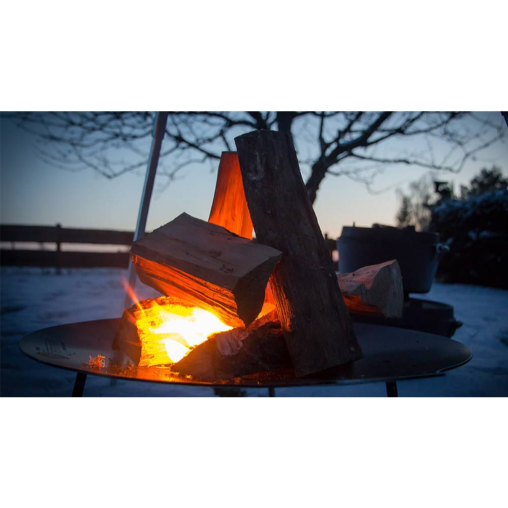 Round steel fire bowl with sturdy legs holding burning firewood, creating a warm outdoor ambiance at dusk, ideal for Farm, Garden & Tool, Camping, Best Sellers, and Promo Eligible collections.