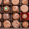 Assortment of handcrafted sugar-free chocolates arranged in a box, showcasing various shapes and textures, made in USA and featured in Kitchen & Food and Candy collections.