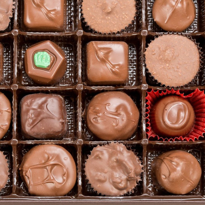 Assortment of handcrafted sugar-free chocolates arranged in a box, showcasing various shapes and textures, made in USA and featured in Kitchen & Food and Candy collections.