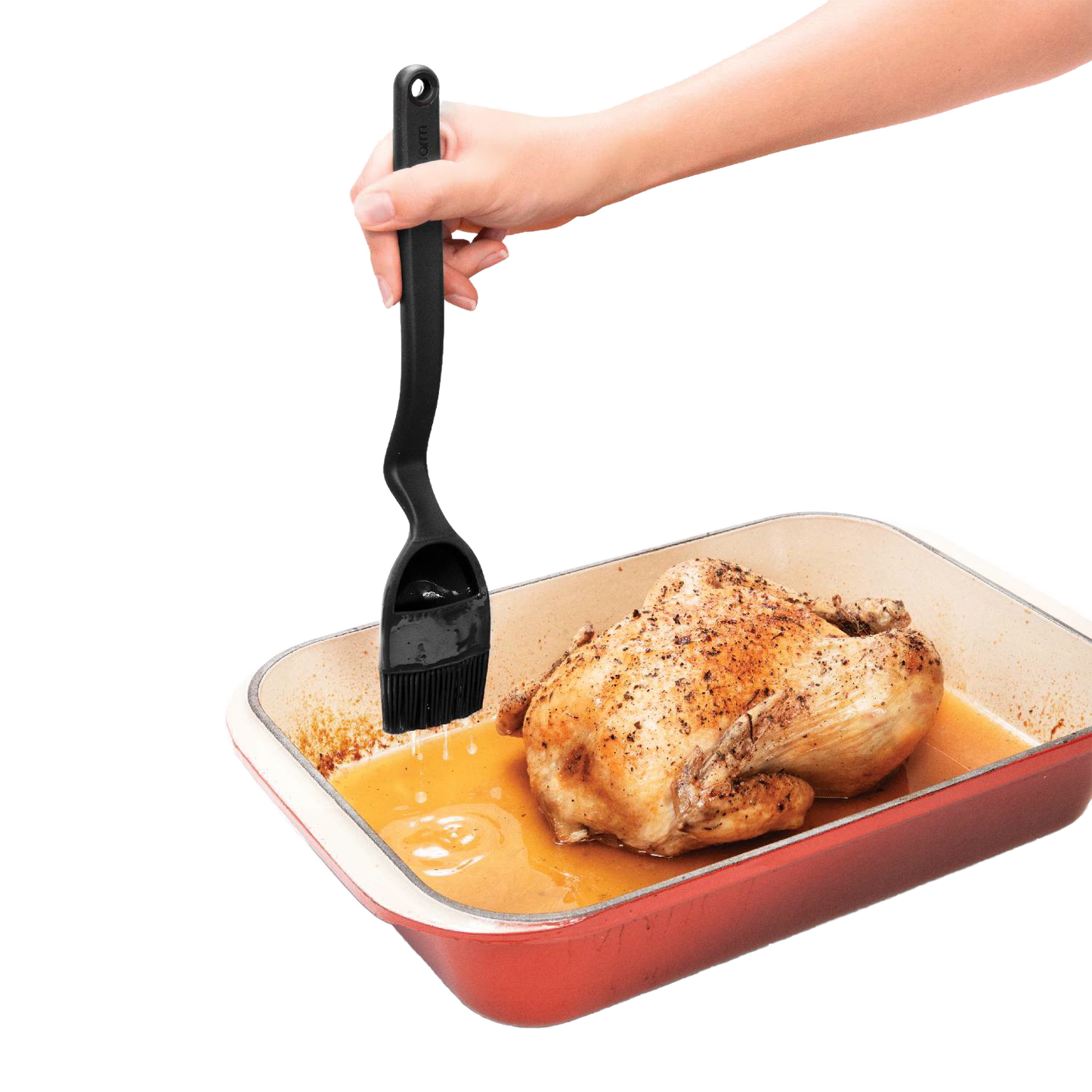 Black basting brush with ergonomic handle and flexible head designed for controlled liquid release over roasted chicken in a baking dish, ideal for Kitchen & Food and Grilling collections.