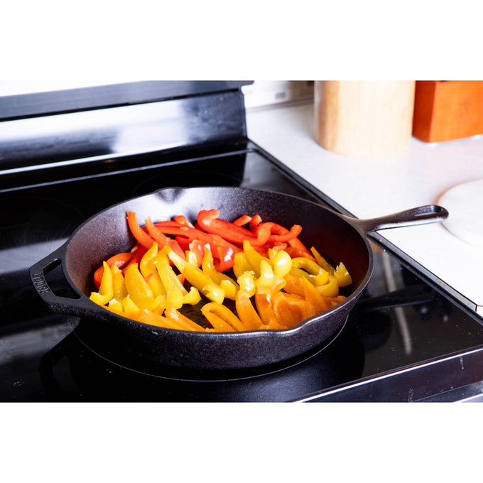 Handcrafted 12-inch cast iron skillet cooking sliced red and yellow bell peppers on a stovetop, featured in Kitchen & Food, Cookware, Cast Iron, USA Made, and Best Sellers collections.