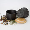 Handcrafted cast iron spice grinder set with bamboo lid and silicone gasket, surrounded by mixed peppercorns and fresh thyme, part of Kitchen & Food, Kitchen Gadgets, and Best Sellers collections.