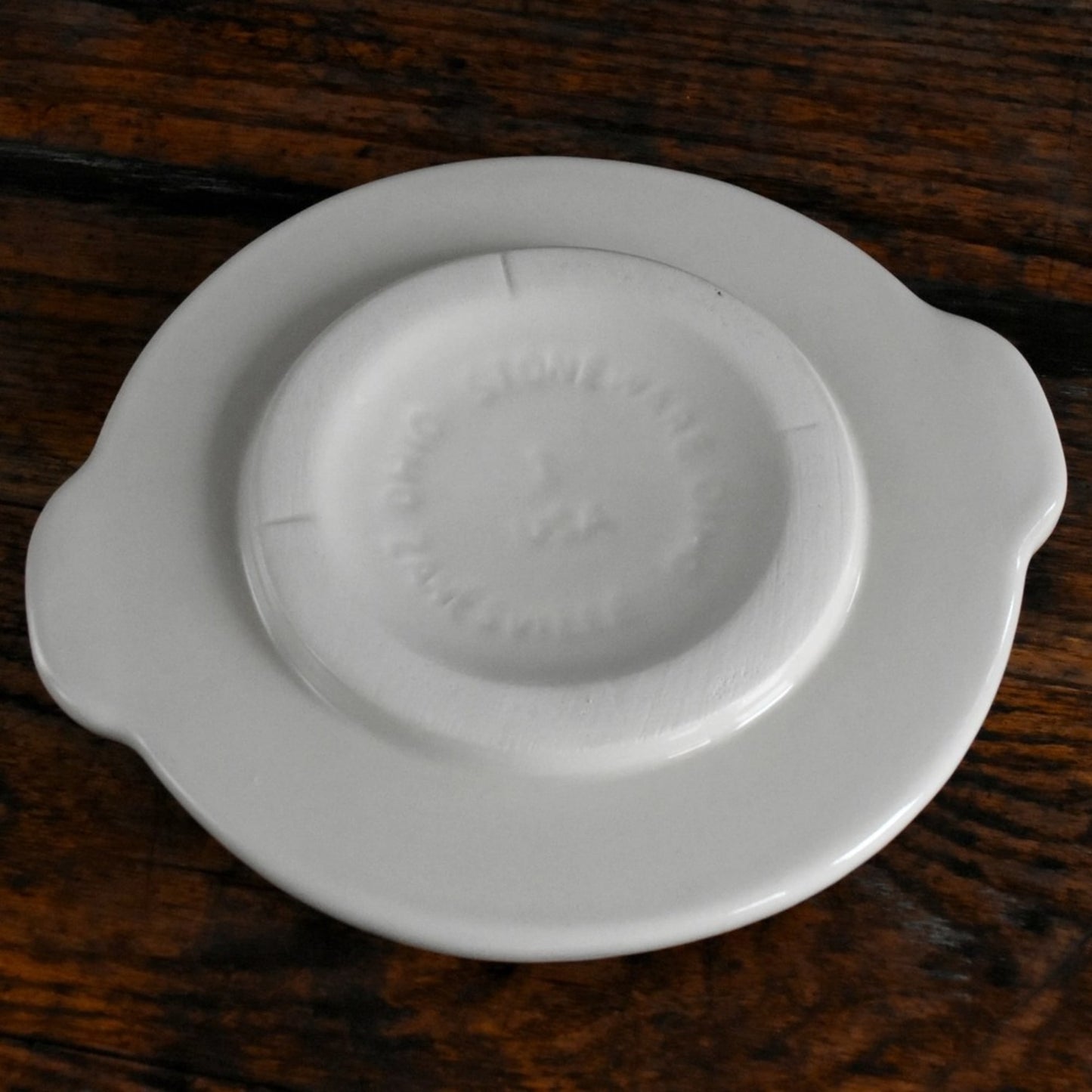 Handcrafted cream-colored stoneware crock cover with side handles, made in USA, designed for food preservation and fermenting in kitchen and pickling collections.